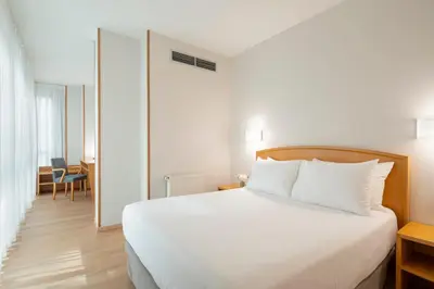 a bedroom with a white bed and a table at Exe Area Central in Santiago de Compostela