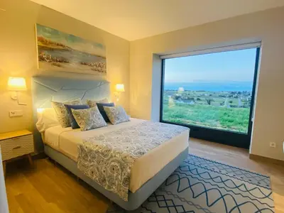 a bedroom with a bed and a large window at El Pueblín del Pinar in Navia
