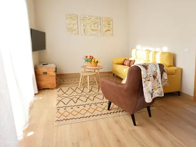 a living room with a couch and a chair at El Pueblín del Pinar in Navia