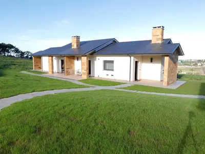 a house with a green lawn in front of it at El Pueblín del Pinar in Navia