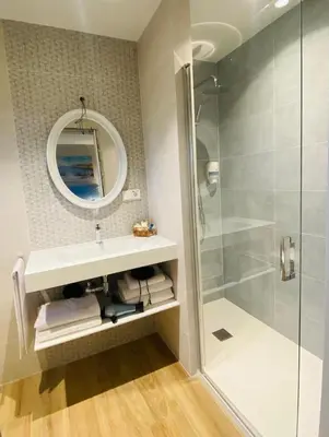a bathroom with a shower and a sink and a mirror at El Pueblín del Pinar in Navia