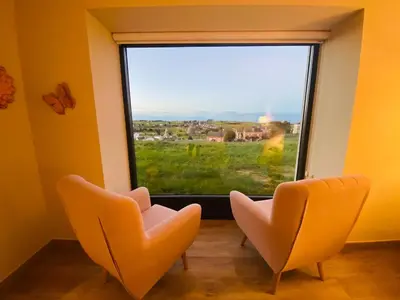 two chairs in front of a window with a view at El Pueblín del Pinar in Navia