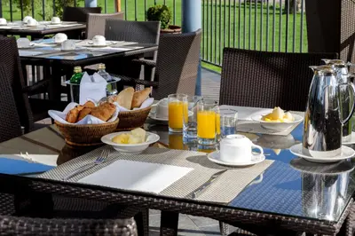 a table with a breakfast of bread and orange juice at Eurostars Vila de Allariz Hotel Balneario in Allariz