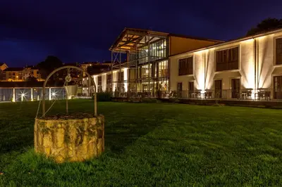 a building with a tree stump in the yard at night at Eurostars Vila de Allariz Hotel Balneario in Allariz