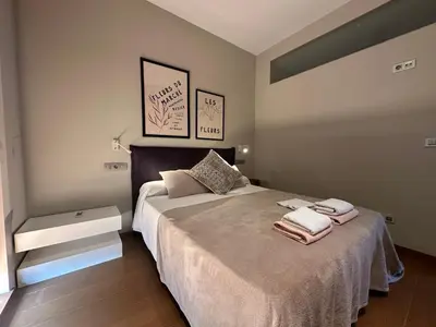 a bedroom with a bed with two towels on it at Apartamento Sta Cruz 2 Dormitorios in A Coruña