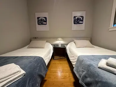 two beds in a room with a nightstand between them at Apartamento Sta Cruz 2 Dormitorios in A Coruña