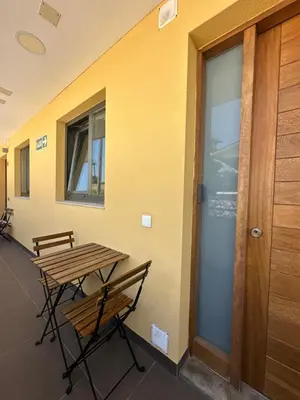 a table and chairs next to a wall with a door at Apartamento Sta Cruz 2 Dormitorios in A Coruña