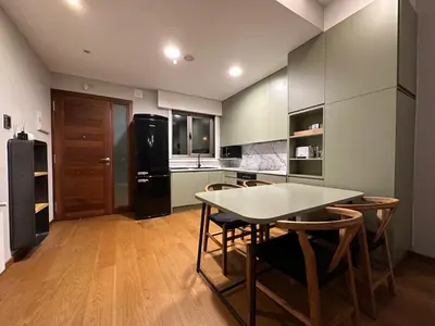a kitchen with a table and chairs and a refrigerator at Apartamento Sta Cruz 2 Dormitorios in A Coruña