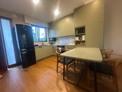 a kitchen with a table and chairs and a refrigerator at Apartamento Sta Cruz 2 Dormitorios in A Coruña