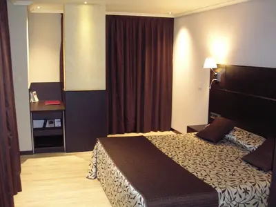 a bedroom with a large bed in a room at Hotel Francisco II in Ourense