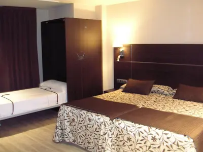 a hotel room with two beds and a cabinet at Hotel Francisco II in Ourense