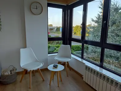 two chairs and a table in a room with windows at Casa Rigo en Sigüeiro, cerca de Santiago de Compostela in Sigüeiro