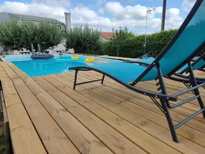 a deck with a chair next to a swimming pool at Casa Rigo en Sigüeiro, cerca de Santiago de Compostela in Sigüeiro