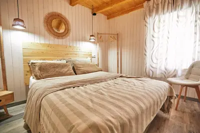 a bedroom with a large bed and a chair at Casa Montse. Apartamentos turísticos in Ribadeo