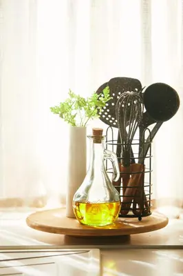 a bottle of oil on a wooden table with a vase at Casa Montse. Apartamentos turísticos in Ribadeo