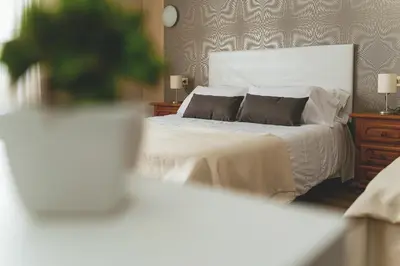 a bedroom with a white bed with two pillows at Hotel Voar in Ribadeo