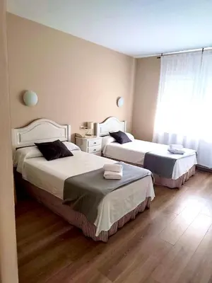 a bedroom with two beds and a window at Hotel Voar in Ribadeo