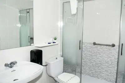 a bathroom with a toilet and a sink and a shower at Hotel Voar in Ribadeo