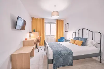 a bedroom with a bed and a desk and a television at Dadá Coliving & Rooms by Serendipia Turismo in Santiago de Compostela