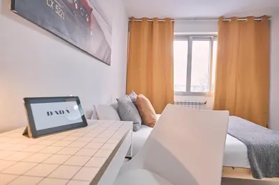 a living room with a table with a laptop on it at Dadá Coliving & Rooms by Serendipia Turismo in Santiago de Compostela