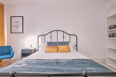 a bedroom with a large bed with yellow pillows at Dadá Coliving & Rooms by Serendipia Turismo in Santiago de Compostela