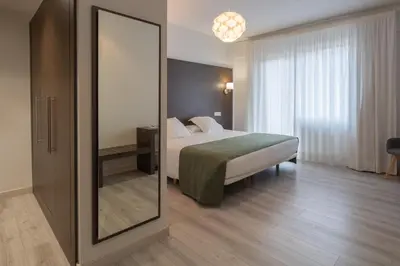 a hotel room with a bed and a mirror at Hotel Mendez Nuñez in Lugo