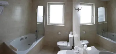 a bathroom with a tub and a toilet and a sink at Hotel Mendez Nuñez in Lugo