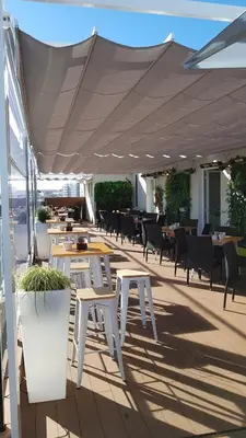 a patio with tables and chairs under a white canopy at Hotel Mendez Nuñez in Lugo