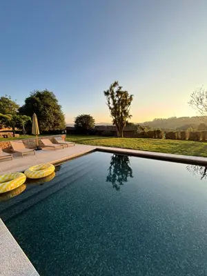 a swimming pool with two lounge chairs next to a field at Lar do Gado in Porta