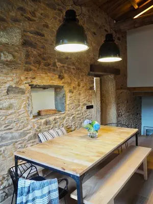 a wooden table in a room with a stone wall at Lar do Gado in Porta