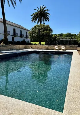 a swimming pool with two chairs and a building at Lar do Gado in Porta