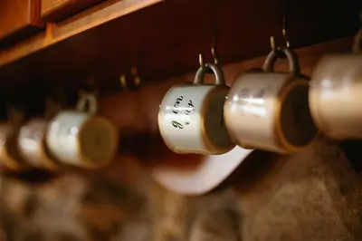 a row of coffee cups hanging on a wall at Apartamentos Rurales La Casina del Fontan in Valle de Lago