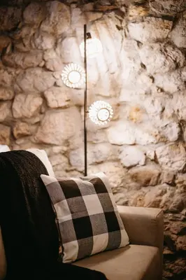 a pillow sitting on a couch with a stone wall at Apartamentos Rurales La Casina del Fontan in Valle de Lago