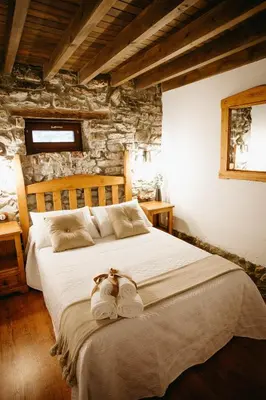 a bedroom with a large bed with two towels on it at Apartamentos Rurales La Casina del Fontan in Valle de Lago