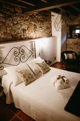 a bedroom with a white bed with two towels on it at Apartamentos Rurales La Casina del Fontan in Valle de Lago