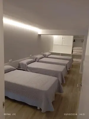 a row of beds lined up in a room at dpCristal Sarria Centro in Sarria