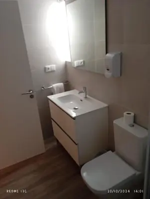 a bathroom with a toilet and a sink and a mirror at dpCristal Sarria Centro in Sarria