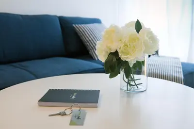 a vase of white flowers on a table with a laptop at Duerming Park Viveiro in Viveiro