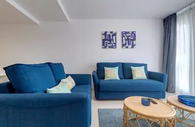 a living room with two blue chairs and a table at Duerming Park Viveiro in Viveiro