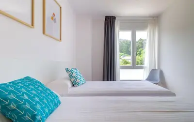 two beds in a room with a window at Duerming Park Viveiro in Viveiro