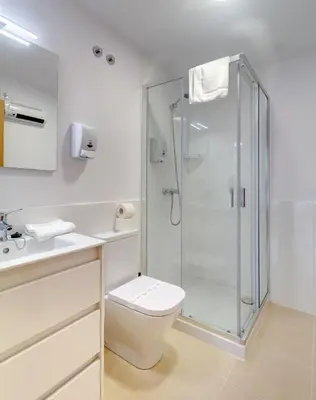 a bathroom with a toilet and a glass shower at Duerming Park Viveiro in Viveiro