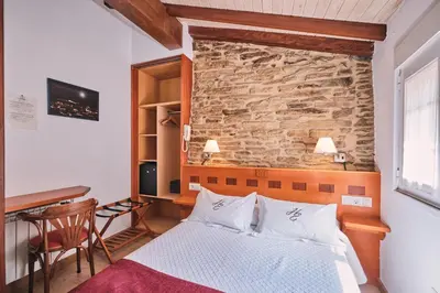 a hotel room with a bed and a desk at Hotel Entrecercas in Santiago de Compostela