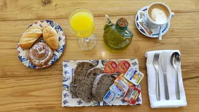 a table with a plate of breakfast food and a glass of orange juice at Hotel A Marisqueira I Aeropuerto A Coruña in Oleiros