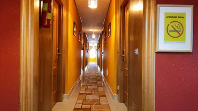 a hallway with yellow walls and a sign on the wall at Hotel A Marisqueira I Aeropuerto A Coruña in Oleiros