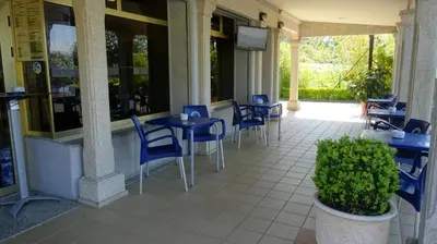 a patio with blue tables and chairs in a restaurant at Hotel A Marisqueira I Aeropuerto A Coruña in Oleiros