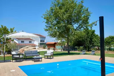 a pool with chairs and an umbrella next to a house at Casa dos Alén in Ourense