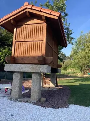 a wooden bird house sitting on a pile of gravel at Casa dos Alén in Ourense
