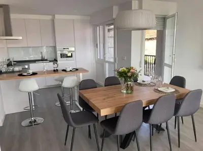 a kitchen and dining room with a wooden table and chairs at Casa dos Alén in Ourense