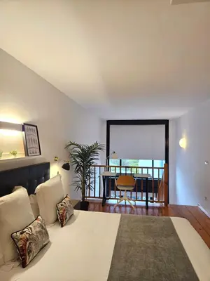 a bedroom with a bed and a dining room at Apartamentos Ciudad Santiago in Santiago de Compostela