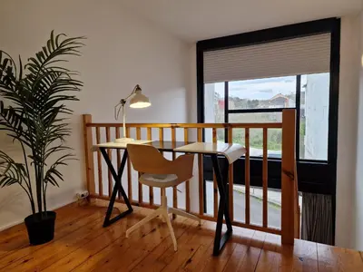 a desk and chair in a room with a balcony at Apartamentos Ciudad Santiago in Santiago de Compostela
